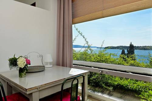 サロにあるVilla Raoulのテーブルと景色を望む窓が備わる客室です。