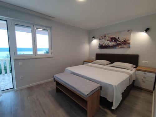 ein Schlafzimmer mit einem großen Bett und zwei Fenstern in der Unterkunft Apartments Ivančić in Mimice