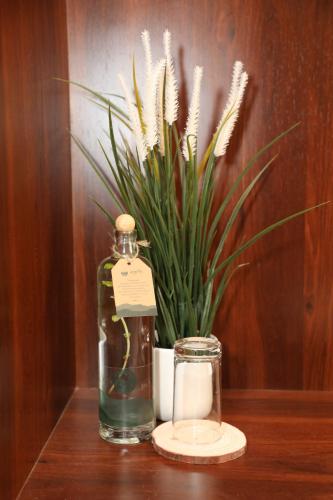 a bottle and a candle and a plant on a table at Earth Hotels in Bengaluru