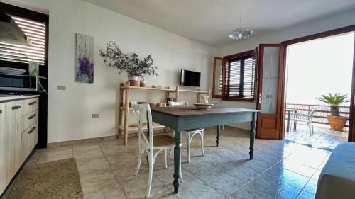 a kitchen with a table and chairs in a room at Marina di Andrano - Alisso, casa vista mare con parcheggio privato e wifi in Andrano