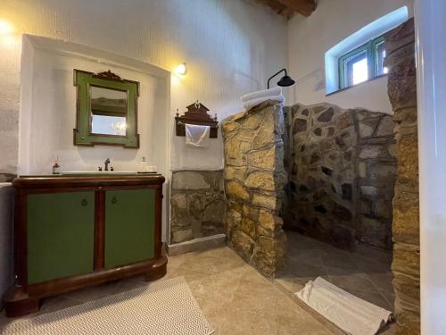 a bathroom with a stone shower and a sink at Kánya Veranda in Szomolya