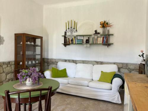 a living room with a white couch and a table at Kánya Veranda in Szomolya