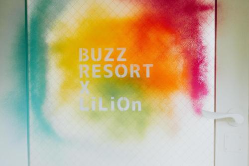 a glass door with the words bulzz resort xilation at Buzz Resort in Onna