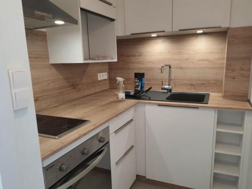 une cuisine avec des armoires blanches et un évier dans l'établissement Vue Belle île, à Quiberon