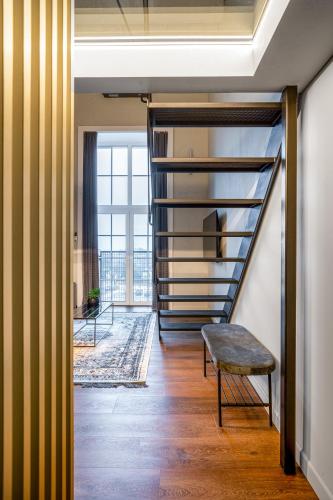 a living room with a staircase and a bench at Stylish Black and White loft in Kaunas