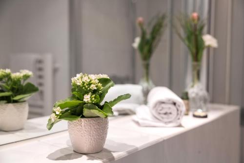 a bathroom counter with two vases with flowers on it at Hotel Stadt Gütersloh in Gütersloh