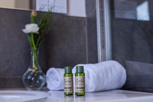 two bottles of moisturizers sitting on a counter in a bathroom at Hotel Stadt Gütersloh in Gütersloh