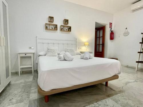 a white bedroom with a large white bed with pillows at El Rincón del Sacristán in Córdoba