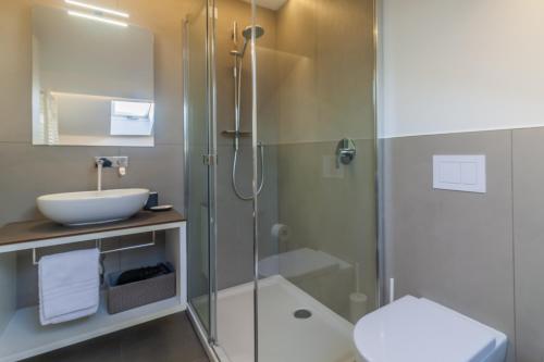 uma casa de banho com uma cabina de duche em vidro e um lavatório. em La Baia by Wonderful Italy em Bellagio