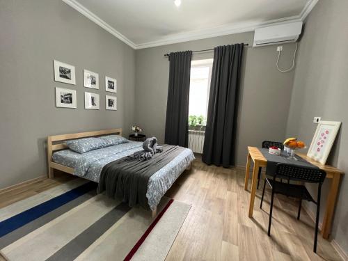 a bedroom with a bed and a table and a window at Гостевой Отель-125 in Aktau