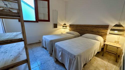 a hotel room with two beds and a window at Marina di Andrano - Alisso, casa vista mare con parcheggio privato e wifi in Andrano
