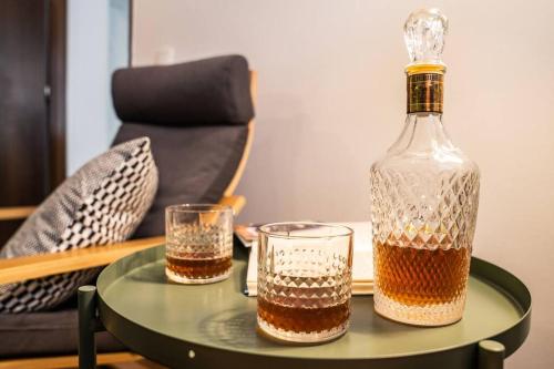 una bottiglia di alcol e due bicchieri su un tavolo di Gentlemen's Apartment near Brno-Center a Brno