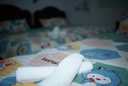a white roll of paper on a bed with hello kitty items at Jaymo Motel in Vung Tau
