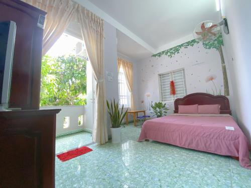 um quarto com uma cama rosa e uma grande janela em Jaymo Motel em Vung Tau