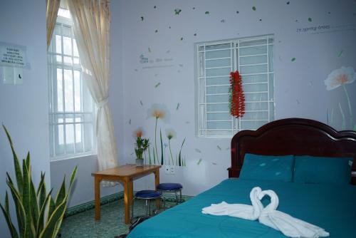 Jaymo Motel في فنغ تاو: غرفة نوم بسرير وطاولة ونوافذ