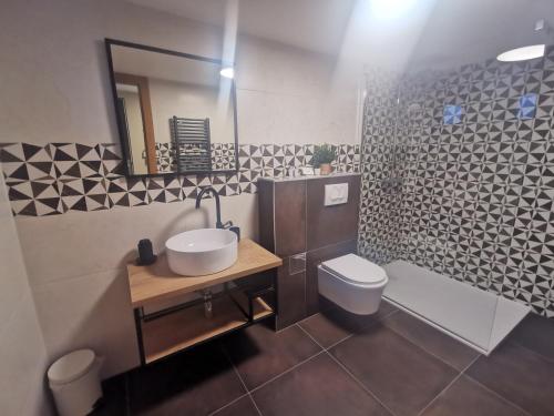 W łazience znajduje się umywalka, toaleta i lustro. w obiekcie Siora w mieście Nijvice