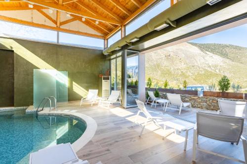 um pátio exterior com uma piscina, cadeiras e uma mesa em Denthis Hotel - Taygetos Mountain Getaway em Artemisía