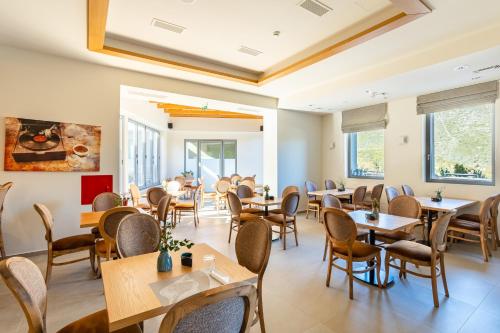 uma sala de jantar com mesas e cadeiras em Denthis Hotel - Taygetos Mountain Getaway em Artemisía