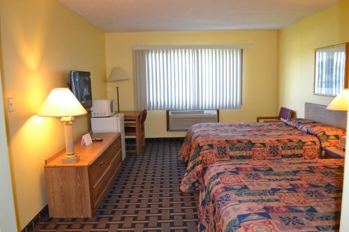 a hotel room with two beds and a television at Sky Lodge Inn & Suites - Delavan in Delavan