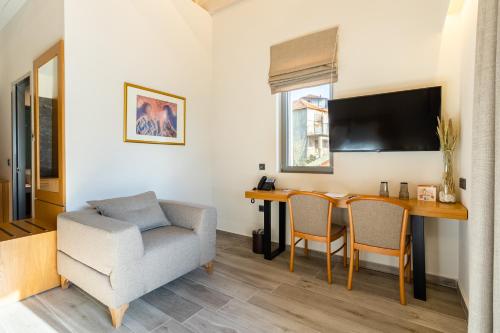 a living room with a table and a chair and a desk at Denthis Hotel - Taygetos Mountain Getaway in Artemisía