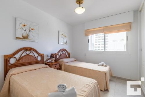 1 Schlafzimmer mit 2 Betten und einem Fenster in der Unterkunft Apartamento Apolo XVI 16 - Grupo Turis in Calpe