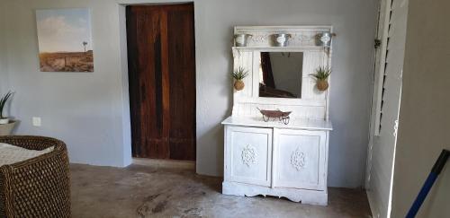 a white cabinet with a mirror in a room at Leopard Tree Retreat in Nelspruit