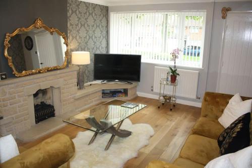 een woonkamer met een open haard en een spiegel bij Gorgeous 3 bed House In Bletchley Milton Keynes in Bletchley