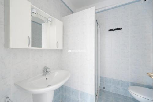 a white bathroom with a sink and a shower at Residence Playa Grande Immobiliare Pacella in Lido di Jesolo