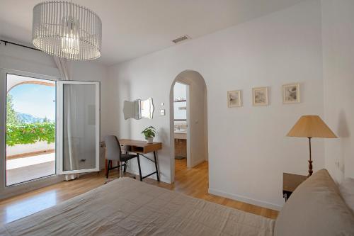 a bedroom with a bed and a table with a desk at Lovely villa with jacuzzi and heated pool in Almuñécar
