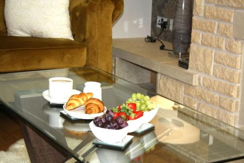 a glass table with two plates of food on it at Gorgeous 3 bed House In Bletchley Milton Keynes in Bletchley