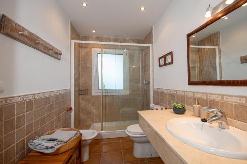 a bathroom with a shower and a sink and a toilet at Lovely villa with jacuzzi and heated pool in Almuñécar