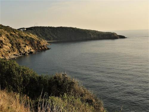 a large body of water with an island in the distance at sunny courtyard in Piombino