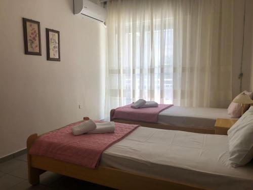 Central apartment في إيراكليتسا: سريرين في غرفة بها نافذة