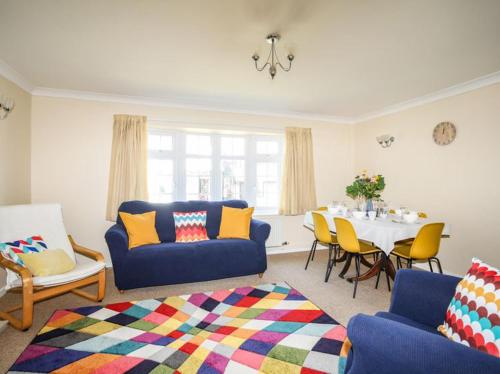 a living room with a blue couch and a table at Homely 4-Bed House close to stunning beach in Pwllheli