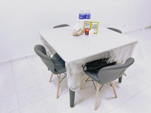 a table with chairs and a white table cloth on it at Simply Cosy Homestay in Batu Caves