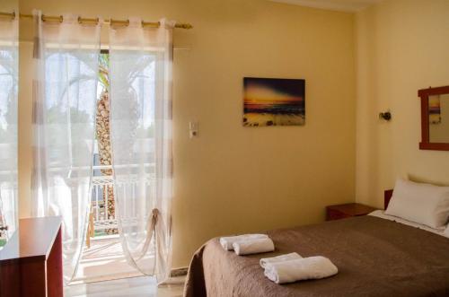 een slaapkamer met een bed met twee handdoeken erop bij Acrogiali Rooms in Rizá