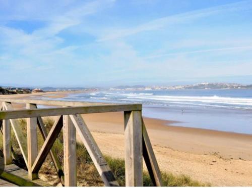een uitzicht op een strand met een houten hek bij Casa Playa Loredo in Loredo