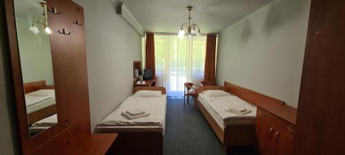 mały pokój z 2 łóżkami i lustrem w obiekcie Leśna Radość w mieście Jastrząb
