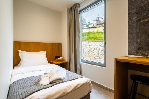 a bedroom with a bed with two towels on it at Denthis Hotel - Taygetos Mountain Getaway in Artemisía