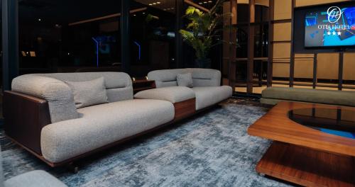 sala de estar con 2 sofás y TV en OTIA HOTEL en Maputo