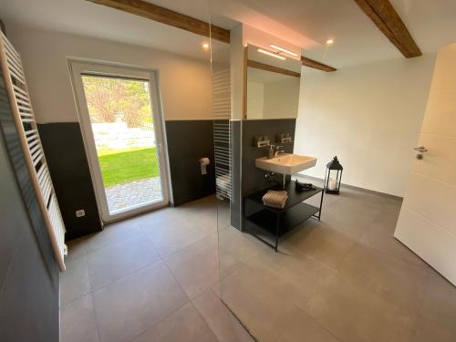 ein Bad mit einem Waschbecken und einem Spiegel in der Unterkunft Ferienhaus „Am Sandstein“ in Papstdorf