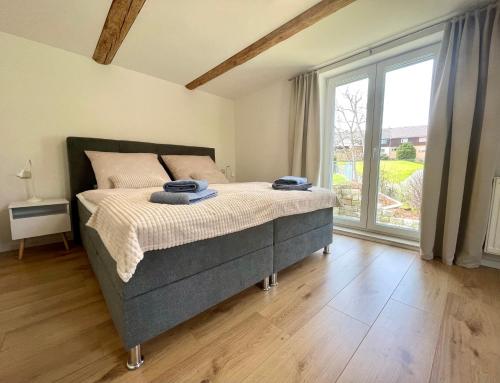 a bedroom with a bed and a large window at Ferienhaus „Am Sandstein“ in Papstdorf