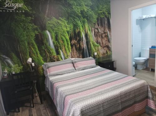 1 dormitorio con 1 cama con un mural de cascada en la pared en Hostal El Bosque Encantado Toledo en Toledo