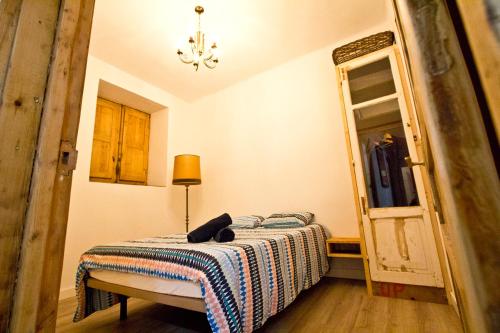 um pequeno quarto com uma cama e um espelho em Beach House San Sebastian em San Sebastián