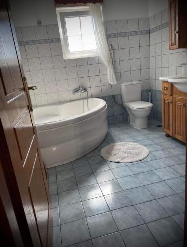 a bathroom with a tub and a toilet at villamaria in Makrádes
