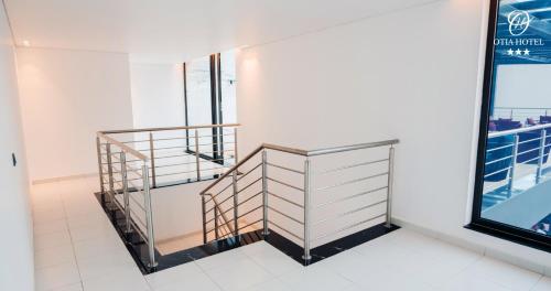 a staircase in a white room with a window at OTIA HOTEL in Maputo