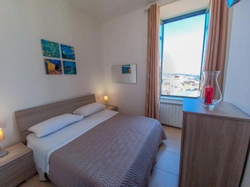 um quarto com uma cama e uma grande janela em L'Affresco Affittacamere em Campolattaro
