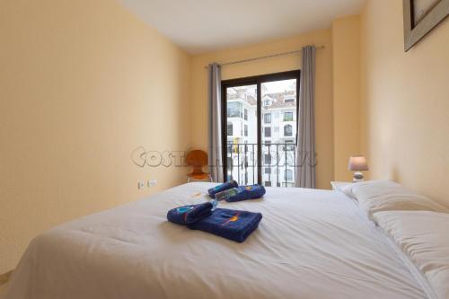 Zwei Handtücher liegen auf einem weißen Bett mit Fenster. in der Unterkunft marina duquesa 839 in Manilva