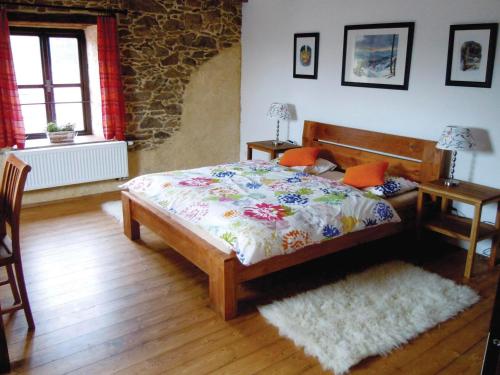 1 dormitorio con 1 cama y 2 mesas. en Farma Mošna, en Zbytiny