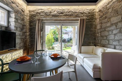 uma sala de estar com uma mesa e um sofá em Loft Favoloso con piscina em Tortolì